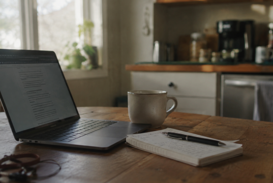 Best Side Hustles From Home: 12 That Actually Pay in 2026 best side hustles from home setup showing laptop and notebook on a kitchen table in morning light