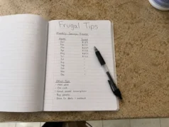 Frugal Living Tips That Actually Work: 15 Worth Keeping frugal living tips written in notebook with monthly savings tracker on kitchen table