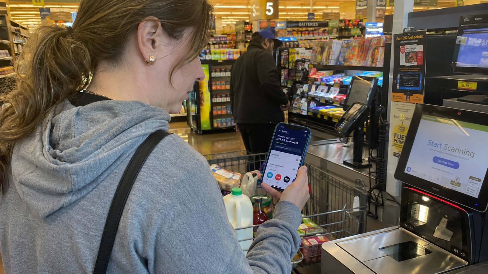 person using cashback app at grocery checkout as one of 15 ways to save money on groceries