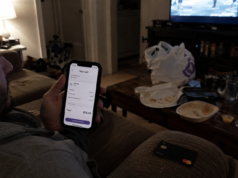 How to Save Money on Food: 8 Changes That Cut Your Bill Fast person sitting on couch looking at food delivery app on phone with credit card in hand late at night